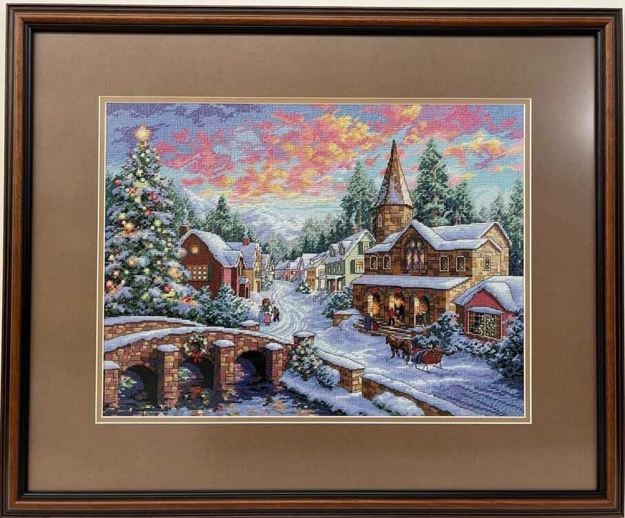 A Christmas village cross-stitch framed.
