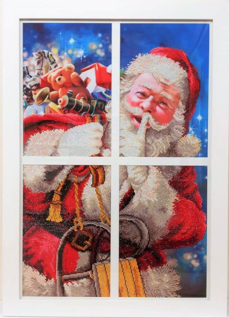 A picture of santa claus in a window frame.