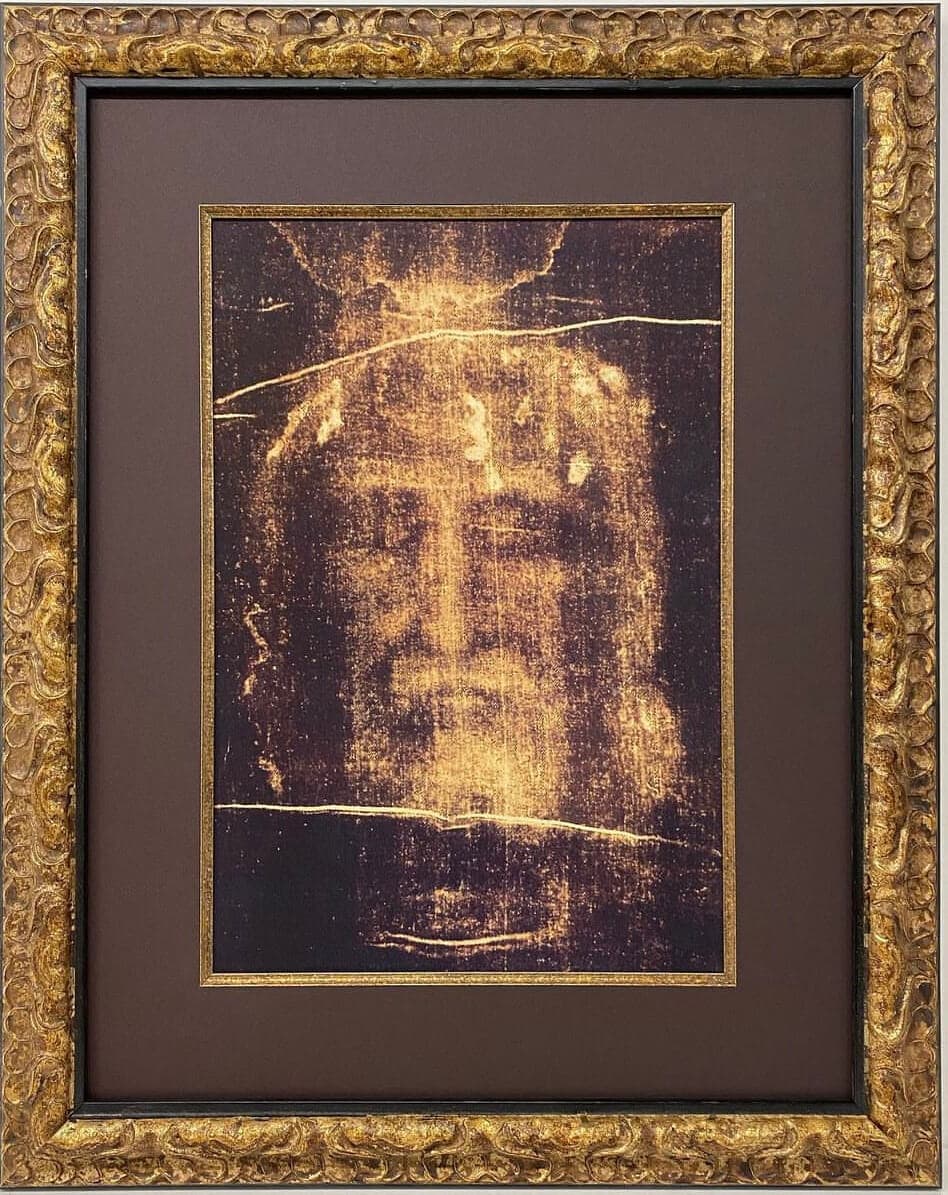 The face of jesus is framed in gold.