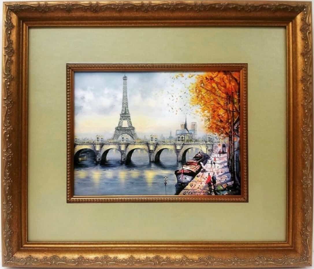 A painting of the eiffel tower in a gold frame.