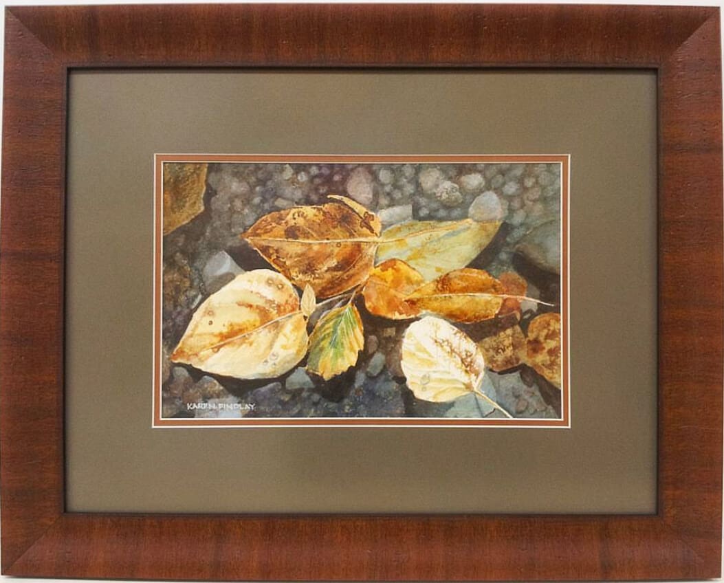 A watercolor painting of autumn leaves in a wooden frame.