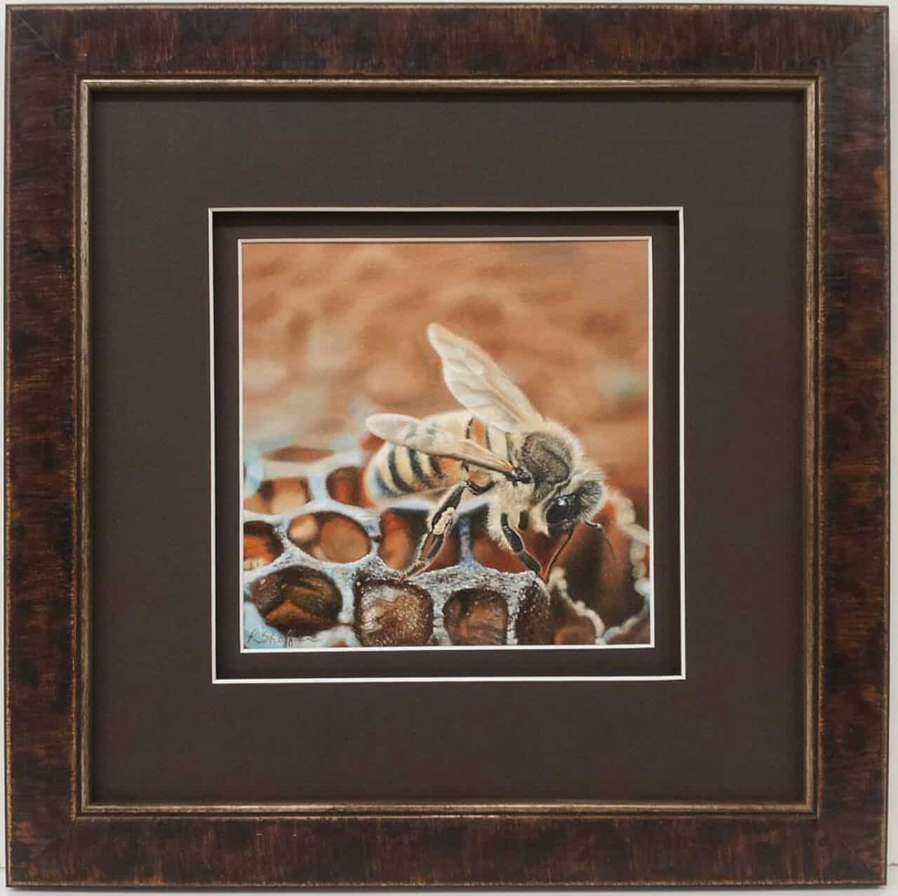 A framed painting of a bee on a honeycomb.